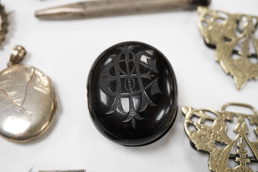 A group of jewellery, comprising: a locket, possibly in jet or bog oak, bearing the initials CIM, the interior with two compartments, length 4.6cm, design registration mark for circa 1861, maker's mark; three mechanical